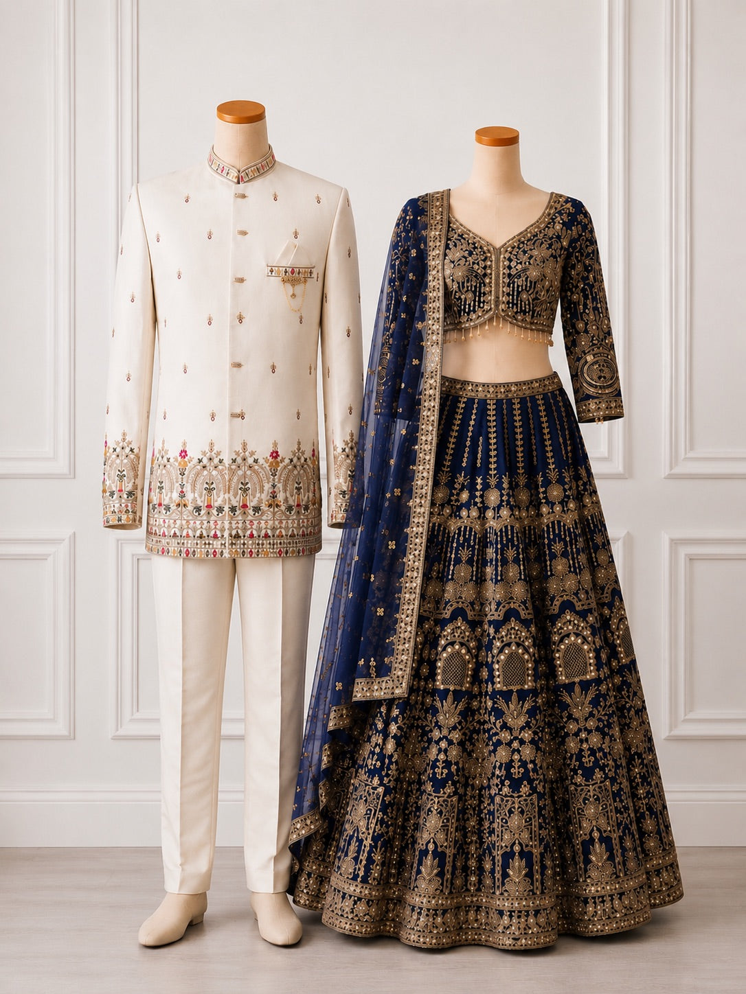 Ivory sherwani and navy blue bridal lehenga couple on mannequins
